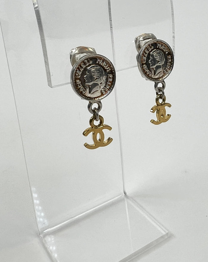 Excellent Pre-Loved Silver Tone Coin Shape Clip On Earrings with Gold Tone Logo Drop. (close up)