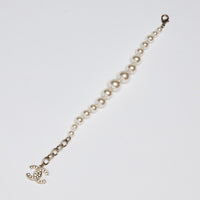 Excellent Pre-Loved Faux Pearl Bracelet with Crystal Embellished Logo Charm. (flat lay)