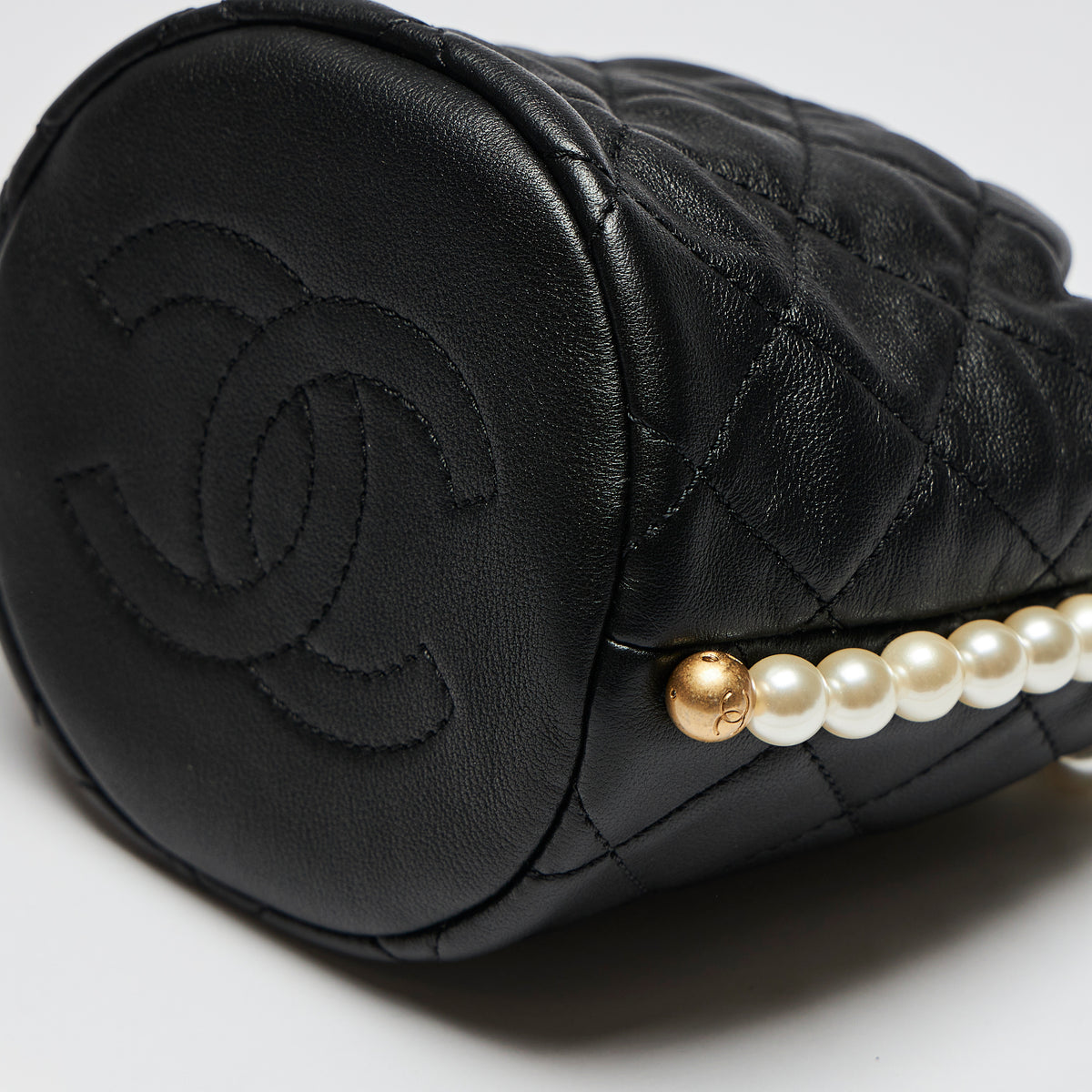 Excellent Pre-Loved Black Quilted Leather Mini Drawstring Bag with Pearl Shoulder Strap.(sides)
