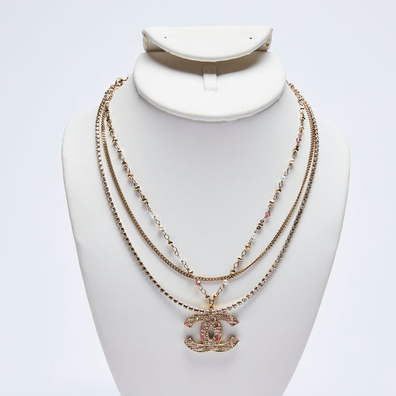 Excellent Pre-Loved Pink Enamel Gold Tone Tweed Textured Logo Pendant Multi-Strand Necklace with Mini Faux Pearls and Pink/White Crystals.(Front)