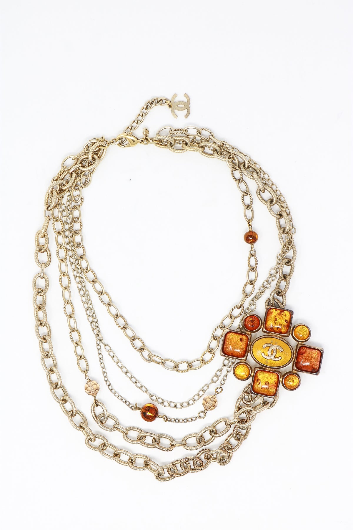 aged gold multichain necklace with orange resin ornament (flat lay view)