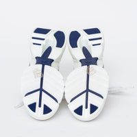 white fabric lace up sneakers with blue logo printed on side (bottom view)