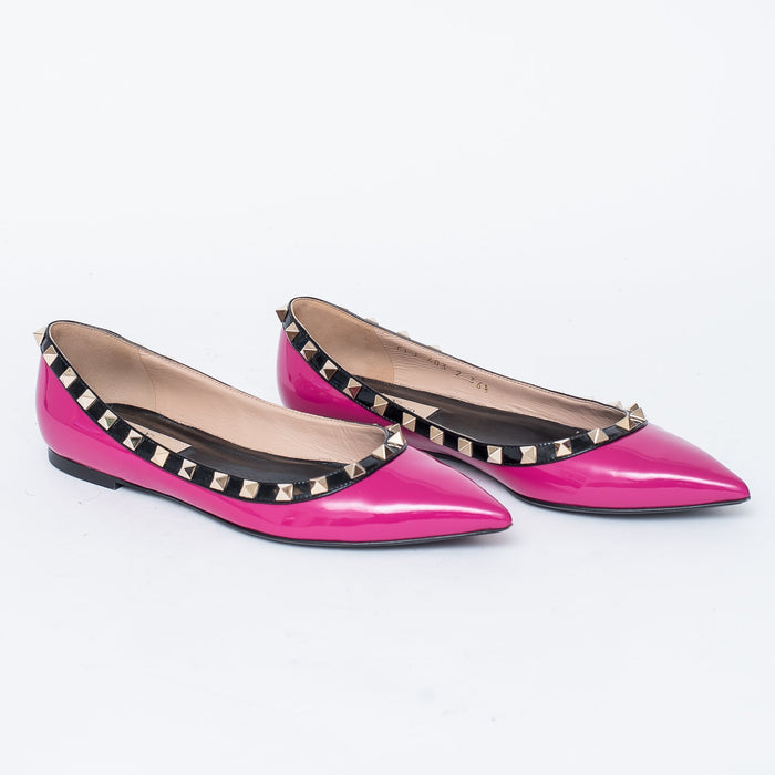 neon pink point toe flats with black leather studded trim (side view)