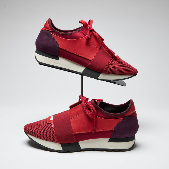 red leather, suede, and mesh mixed material sneakers with white soles (side view)