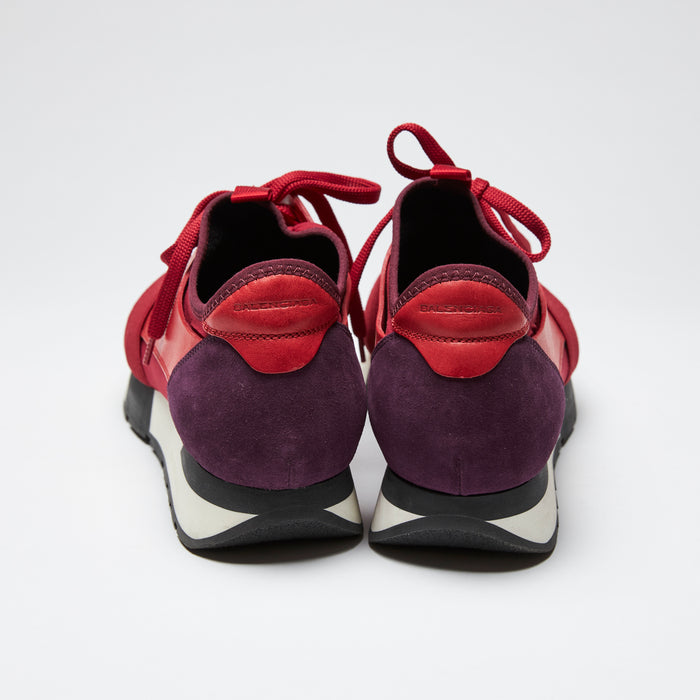 red leather, suede, and mesh mixed material sneakers with white soles (back view)
